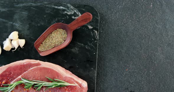 Raw sirloin chop, garlic, rosemary, and spice