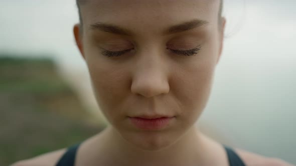 Closeup Woman Opening Eyes Standing on Coast Hill