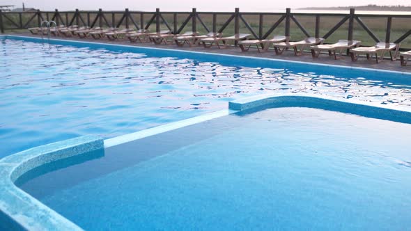 Top View of Swimming Pool with Clear Water on Vacation on Sunset Background