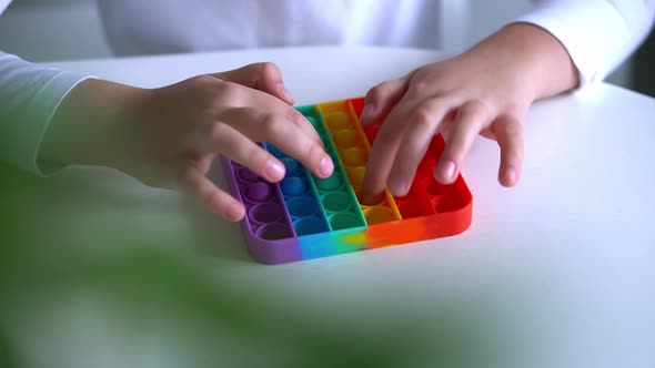 Girl Hands Close Up Playing with Rainbow Pop It Fidget