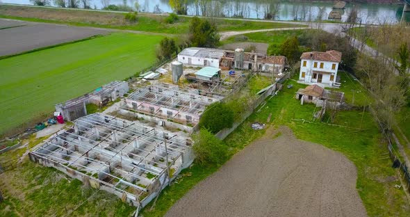 Aerial View of a Ruined and Abandoned Factory Among Green Fields