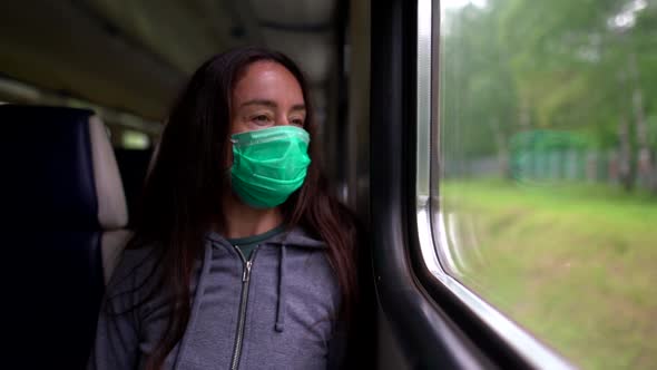 A Close-up Portrait of a Dark-haired, Middle-aged Woman Wearing a Medical Mask. She Is Riding the