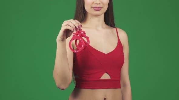 Cropped Shot of a Sexy Woman Smiling Seductively Holding Handcuffs