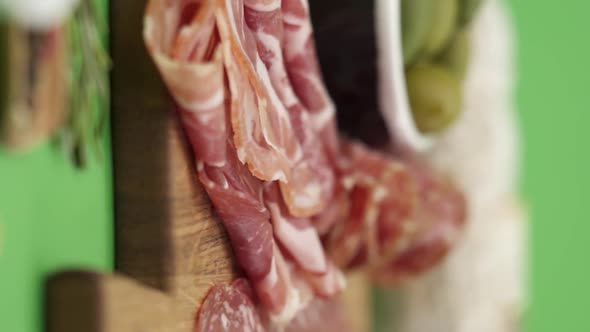 Vertical video, Close-up: cold cuts, salami, prosciutto, jamon, cherry tomatoes, sliced ​​sausage