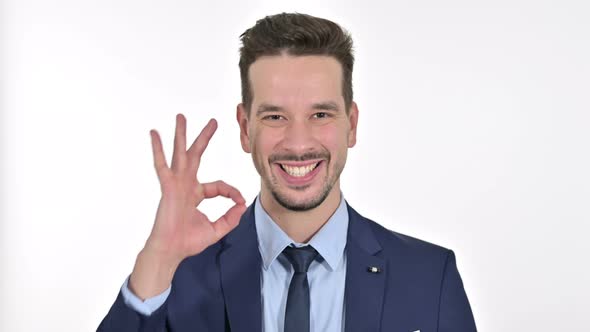 Portrait of Cheerful Young Businessman Doing OK Sign , White Background