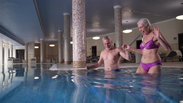 Old Couple Entering Water of Hotel's Swimming Pool