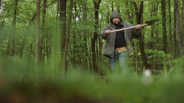 Close-up Of Working with Big Ax in Wild Deciduous Forest.