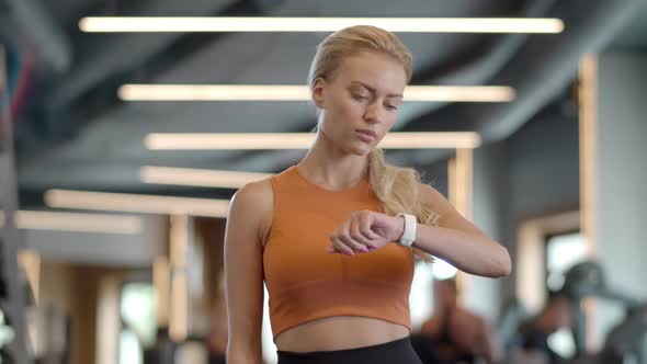 Serious Athlete Girl Checking Results at Gym. Sportswoman Standing in Sport Club