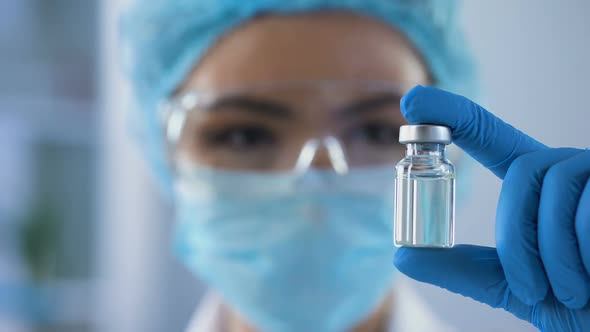 Female Scientist Holding Ampoule in Hand, New Medication Developing, Vaccination