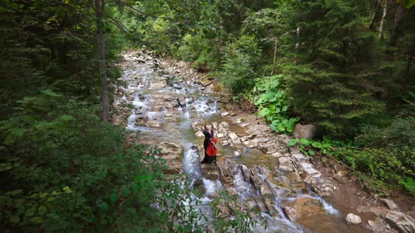 Woman plays cello among beautiful nature. Attractive female cellist playing the musical instrument