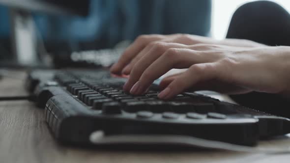 View of Female Hands Typing on Keyboard on Blurred Background