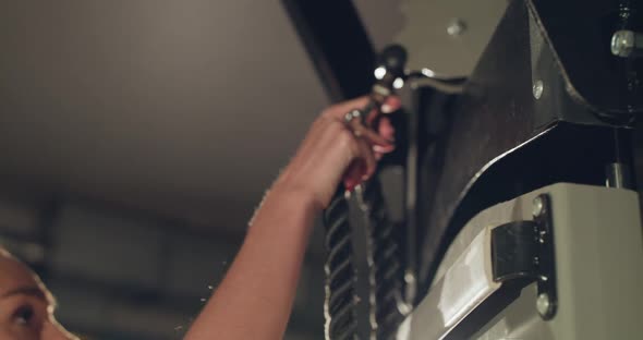 Female Athlete Fixing Up a Sports Rope on Simulator for Training in a Gym