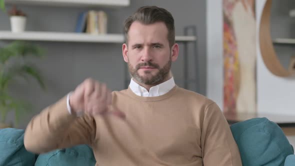 Portrait of Man Showing Thumbs Down at Home