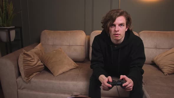 Funny Excited Young Caucasian Man Gamer Winner Holding Joystick Controller Playing Video Games