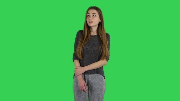 Cute Brunette with Long Hair Is Looking Straight and Smiling on a Green Screen