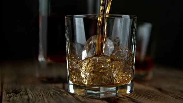 Super Slow Motion Shot of Pouring Whiskey Into Glass with Ice Cubes at 1000Fps with Camera Movement