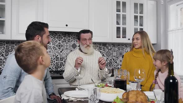 Family of Man, Woman and Their Children with Respected Grandfather Sitting at the Thanksgiving Table