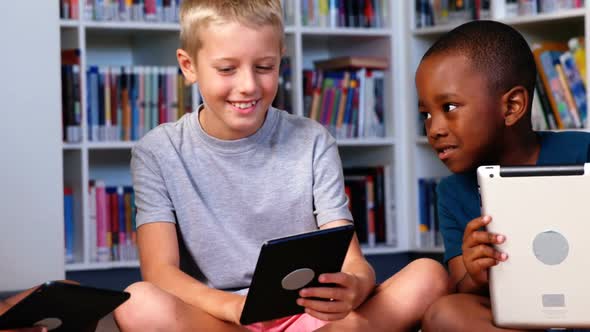 School kids using digital tablet in library