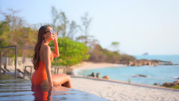 Young asian woman enjoy around outdoor swimming pool for leisure