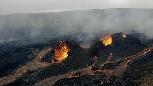 Aerial view of smoke over valley with active, hot and continuous volcanic eruptions.