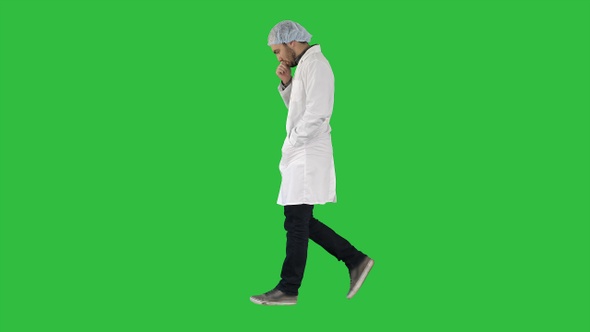 Thoughtful male doctor walking on a Green Screen, Chroma Key