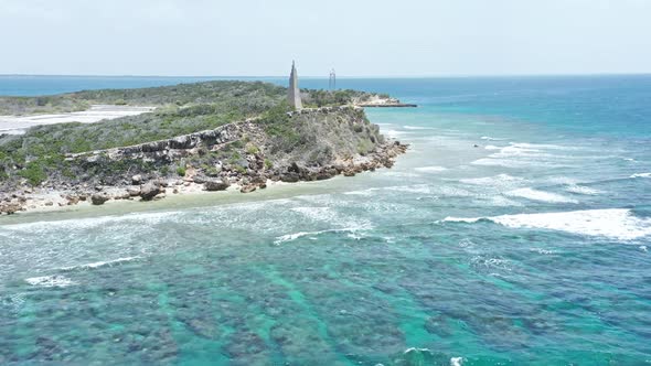 Shallow Blue Sea With Waves Splashing On Rocky Island In Summer. Isla Cabra In The Dominican Republi