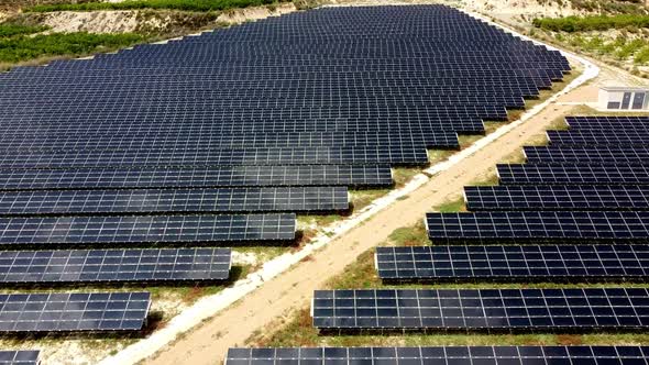 Solar panels farm aerial view from drone shot while sun setting. Small photovoltaic cell panels