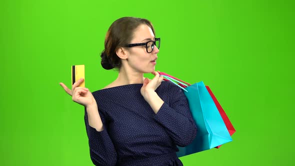 Woman with Bags of Paper Goes Shopping with a Card in Her Hands. Green Screen