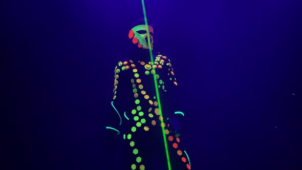 Dancer in Luminous Clothes Mask Turns Green Beam on Stage