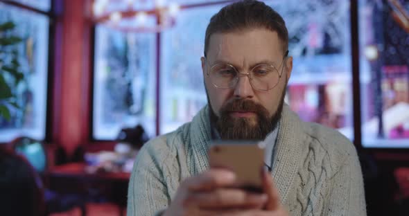 Man Using Smartphone at Cafe