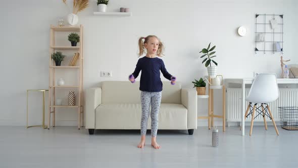 Cute Little Girl Exercising with Dumbbells