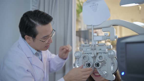 The ophthalmologist is examining the patient's eyes with a specialized machine.