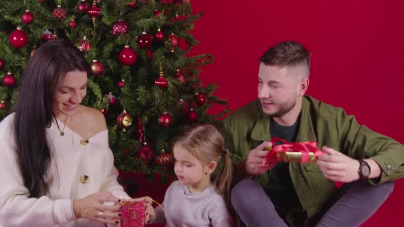 Beautiful Family Giving Christmas Gifts Near Xmas Tree, Magic Holiday Moments