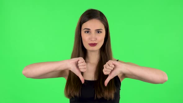 Unhappy Girl Showing Thumbs Down Gesture. Green Screen