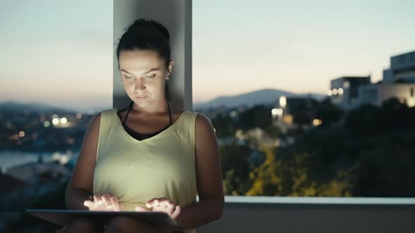 The Girl is Engaged in Business and Works From Home on a Tablet