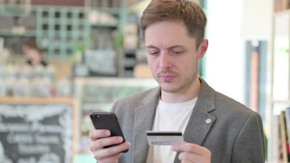 Portrait of Young Man Making Online Payment on Smartphone