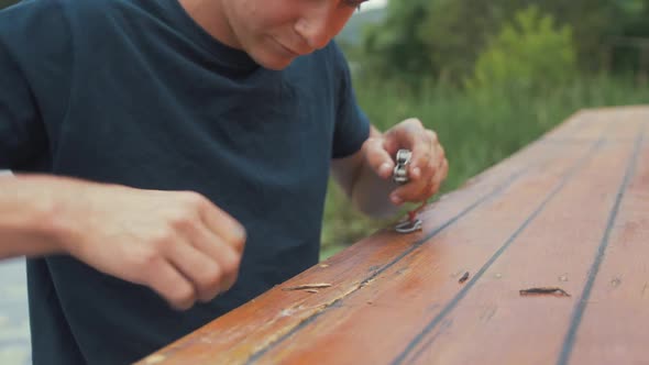 Young man cutting ring old timber with knife wooden boat maintenance. CLOSE UP