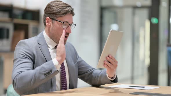 Businessman Doing Online Video Chat on Tablet in Office