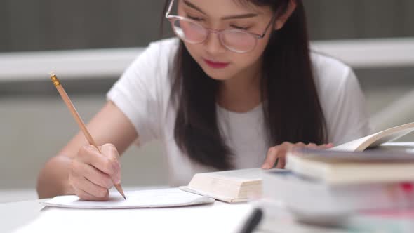 Young undergraduate girl do homework, read textbook, study hard for knowledge and education