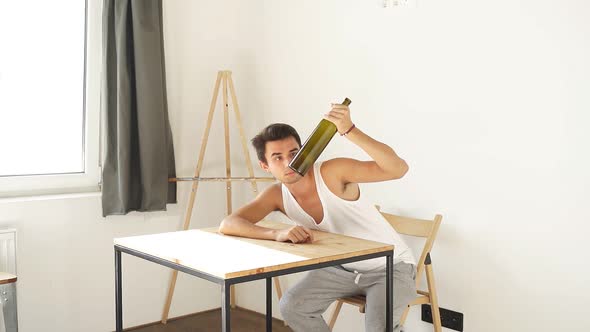 Drunken Man Looks at Empty Bottle of Alcohol Symbol of Alcoholism Depression