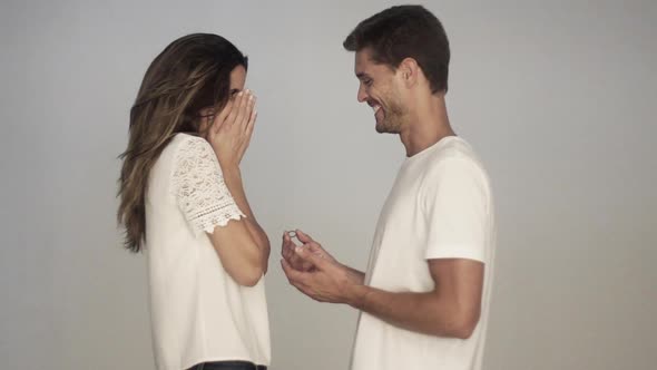 Man surprising woman with engagement ring