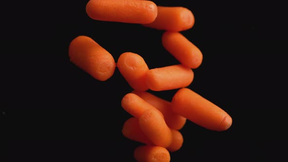 Camera follows throwing carrots into water. Slow Motion.