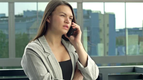 Beautiful Young Woman Talking on the Phone While Standing on a City Street