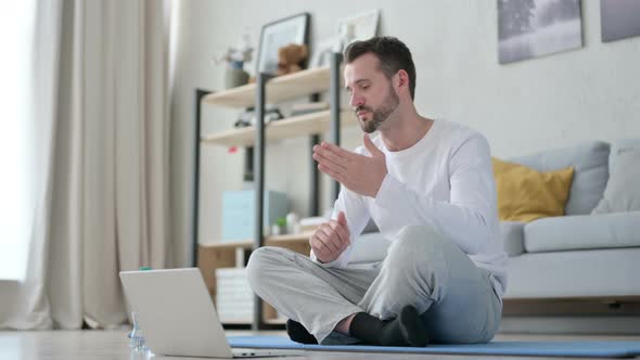 Man Talking on Video Call on Laptop on Yoga Mat