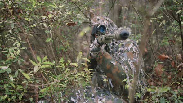 Armed Young Soldier Sniper in a Zone of Armed Conflict in Uniform in Forest Slow Motion