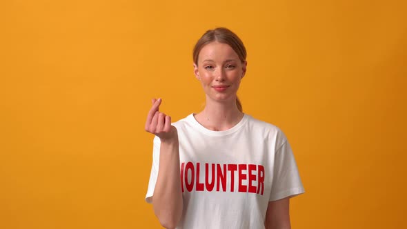 Positive woman volunteer showing Korean heart shape gesture at the camera