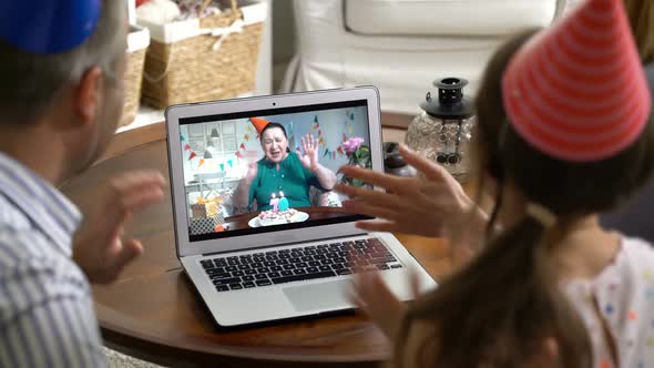A Family with a Child Congratulating a Grandmother on Her Birthday Using a Video Call