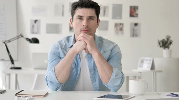 Confident Casual Young Man Sitting at Workplace