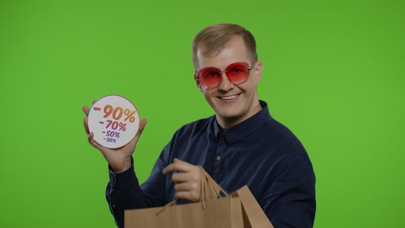 Man with Shopping Bags Showing Great Purchase Discount Percentage Inscription on Black Friday