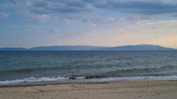 Seaside in Greece with sandy beach and crashing waves. Kavala, Ofrynio.